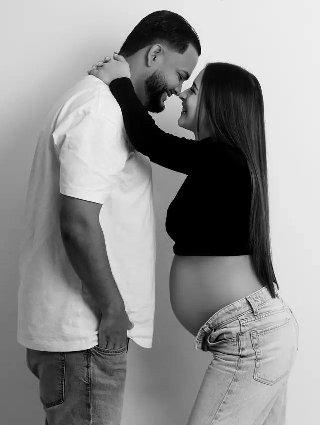 Pareja frente a frente en una sesión de maternidad en blanco y negro